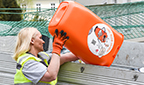 Mitarbeiterin entleert M&uuml;lleimer mit Linz, bleib Sauber! Sujet.