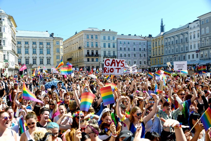 Viele Menschen mit Regenbogenfahnen am Linzer Hauptplatz.